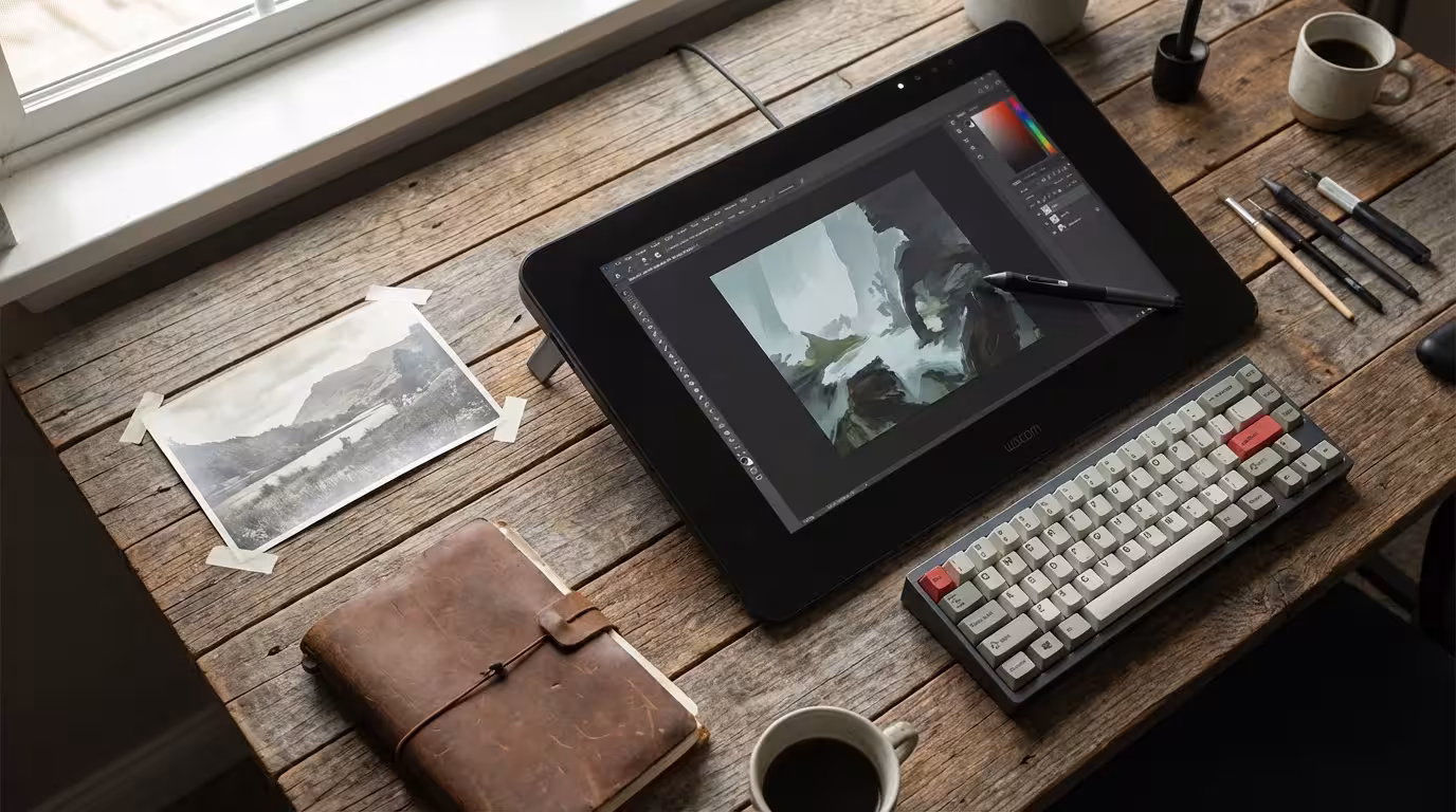 A digital artist's desk with a tablet and stylus used for photo restoration.
