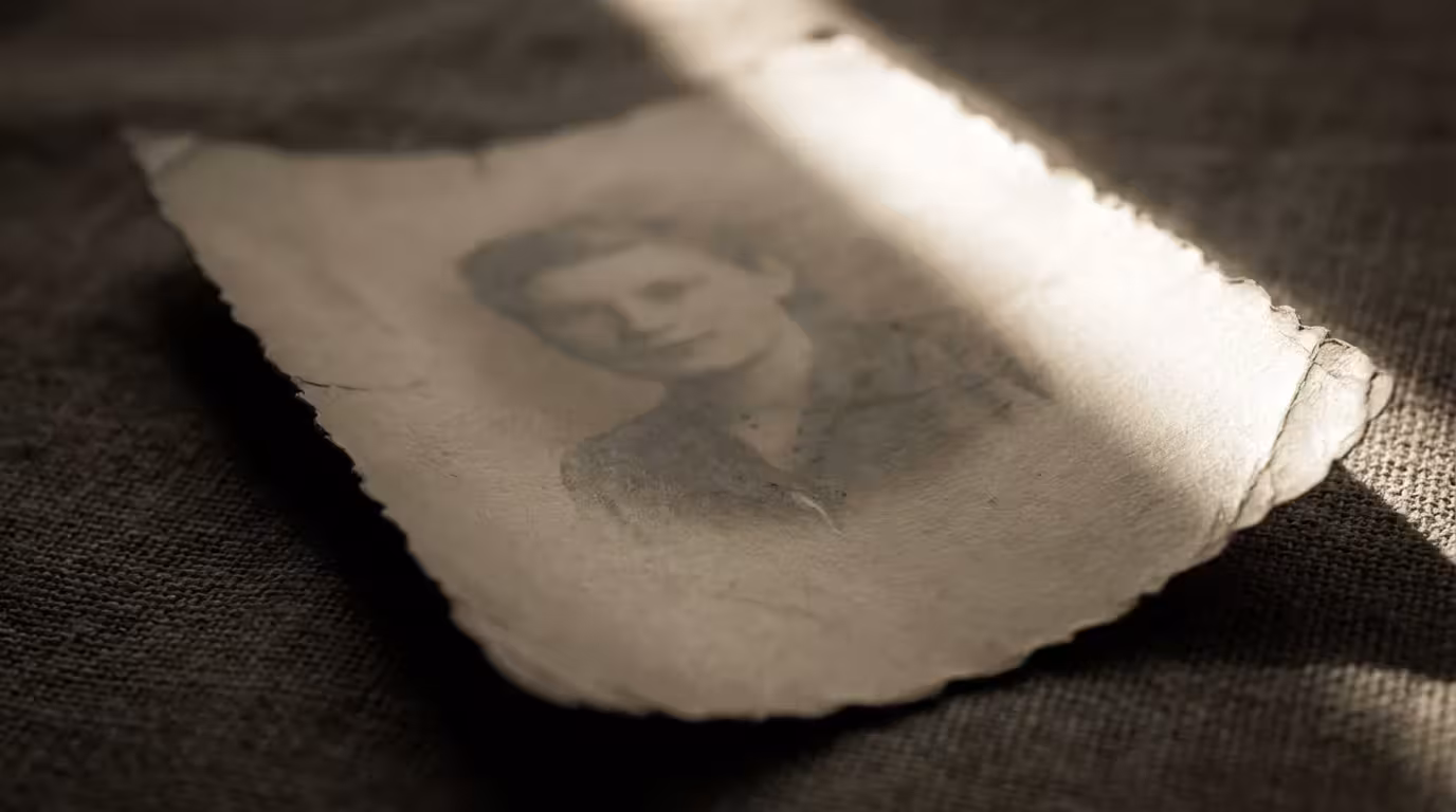 Close-up of a curled vintage photo showing signs of age and light exposure.